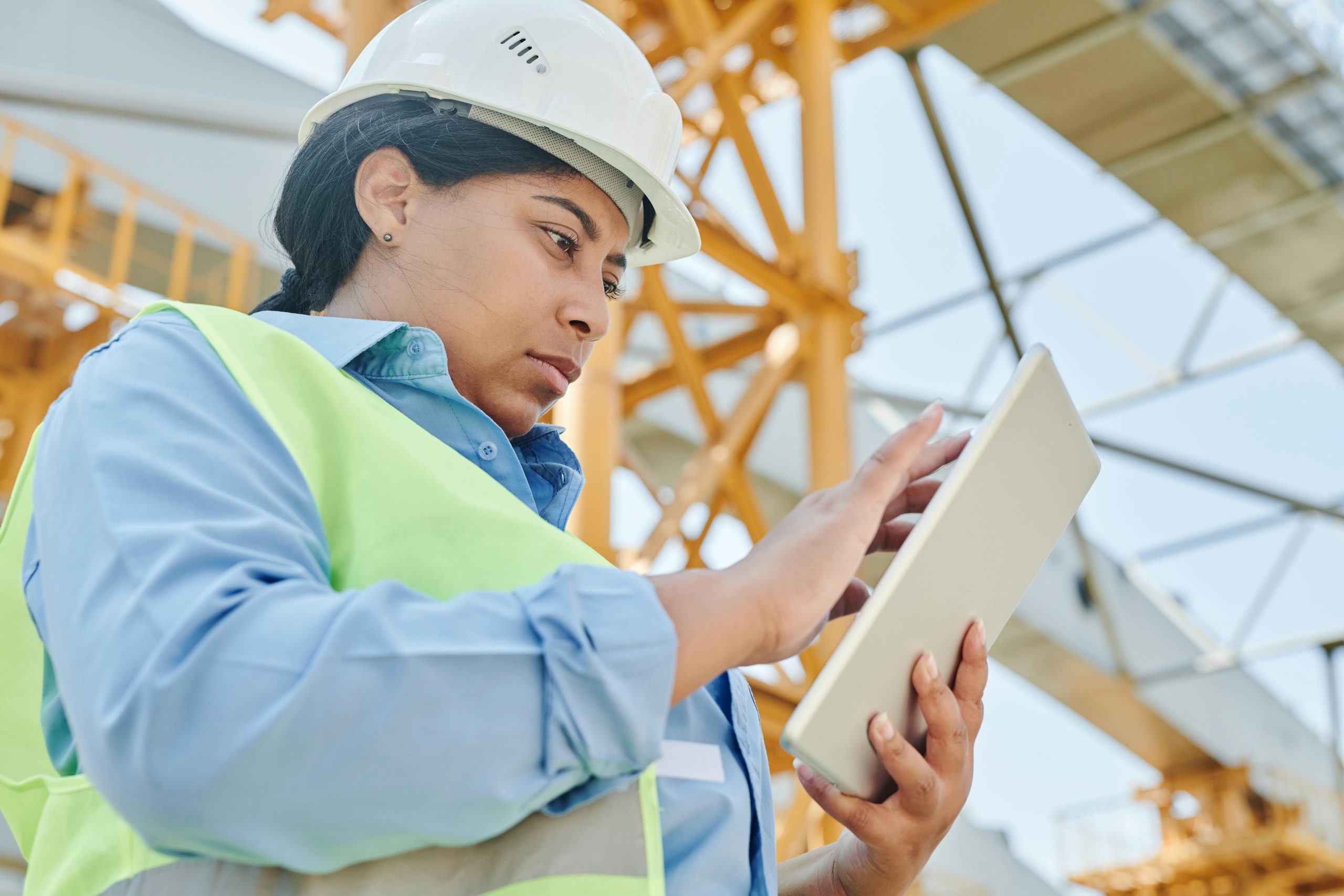Woman in construction gear using tablet with Recorder app.